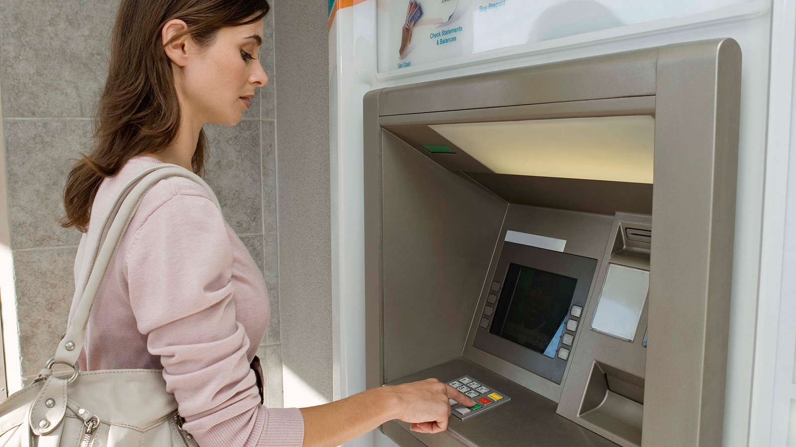 Woman using ATM. Woman using ATM.